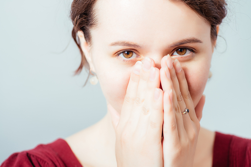 woman covering smile